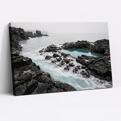 Tableau sur toile représentant une côte rocheuse sombre aux vagues turquoise écumeuses