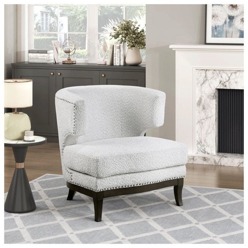 Fauteuil contemporain à dossier demi-tonneau avec revêtement gris bouclé, garniture cloutée et siège à ressorts ensachés