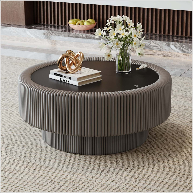 Table basse ronde cannelée avec rangement, plateau en verre trempé et revêtement en cuir gris.