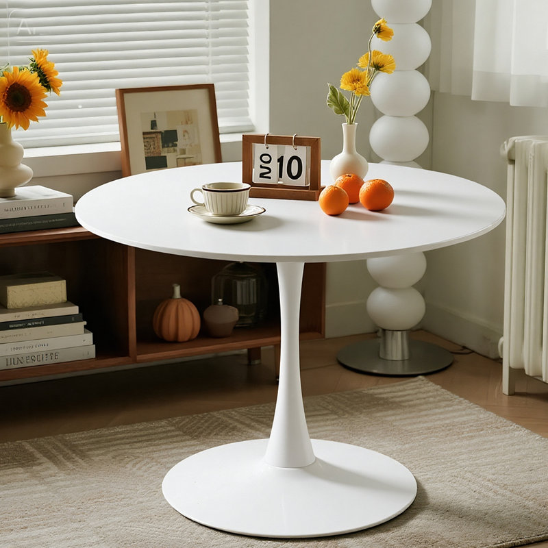 Une table de salle à manger ronde de luxe légère, équipée d'une élégante base en métal en forme de tulipe et d'un plateau de table en panneau de fibres à densité moyenne, présente un style médiéval moderne dans son ensemble