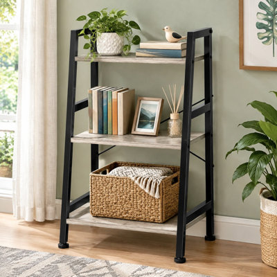 A greige-and-black steel frame gives this compact 3-tier ladder bookshelf its industrial appearance. Use the freestanding metal shelving in bedrooms, kitchens, offices, or living rooms.