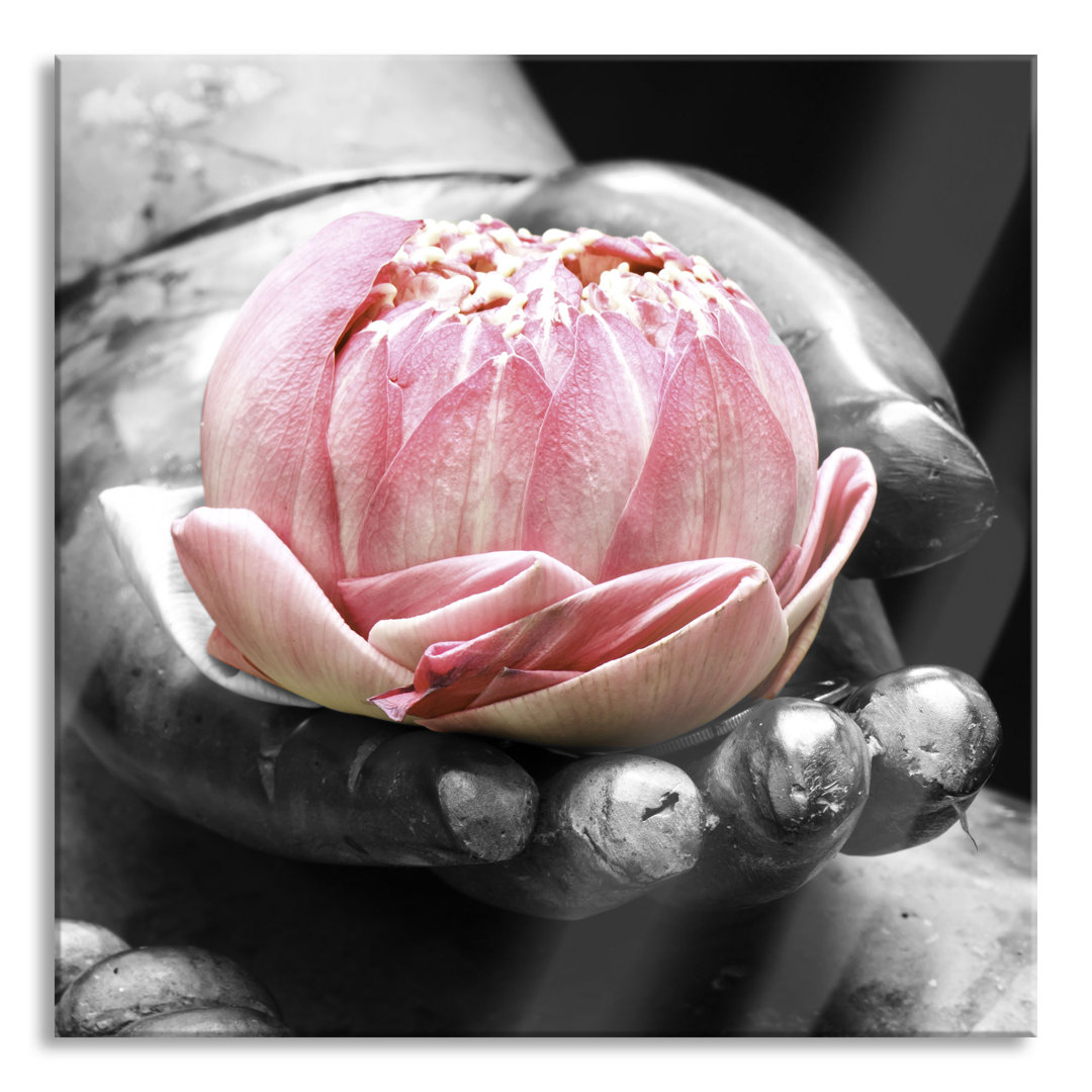 Glasbild Lotus in einer Hand eines Buddhas