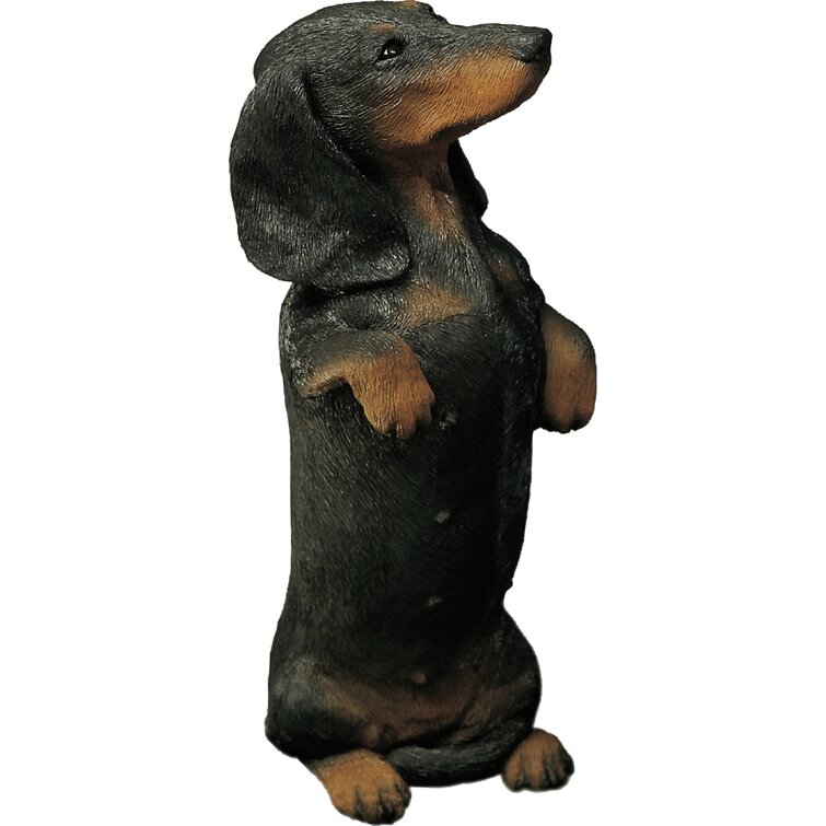 Black and brown dachshund figurine lying on a blue fringe rug realistic