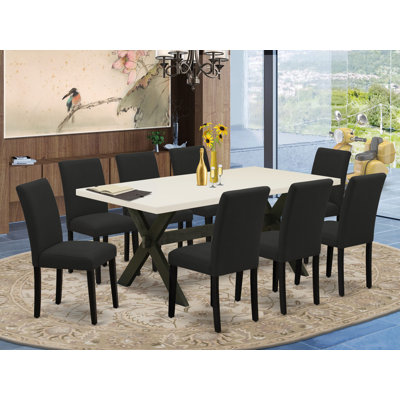 Cet ensemble de salle à manger 9 pièces comprend une table de salle à manger rectangulaire avec pieds en X et 8 chaises Parson rembourrées en tissu de couleur noire, noir brossé