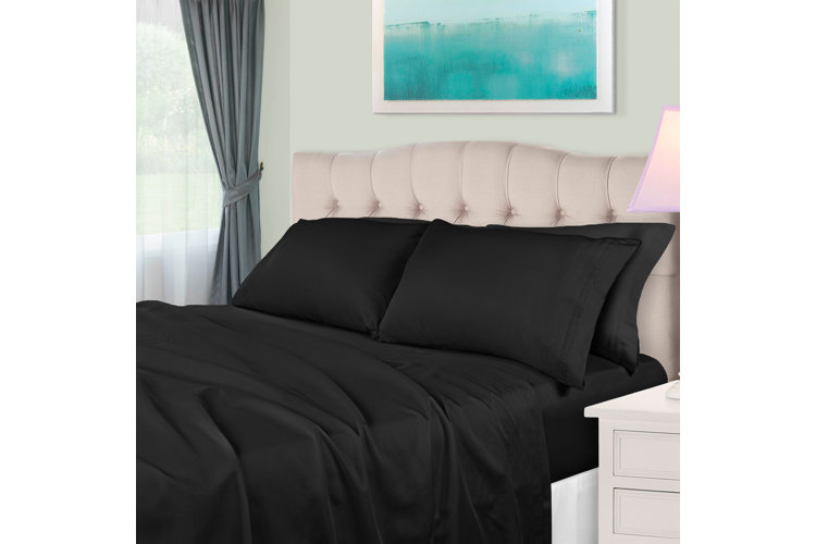 black bedding with velvet tufted headboard