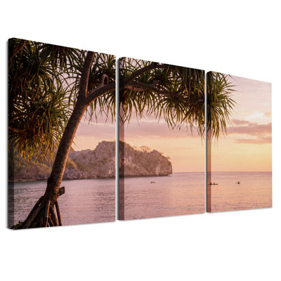 Ensemble de 3 toiles murales représentant un arbre en silhouette encadrant un coucher de soleil rose sur l'océan