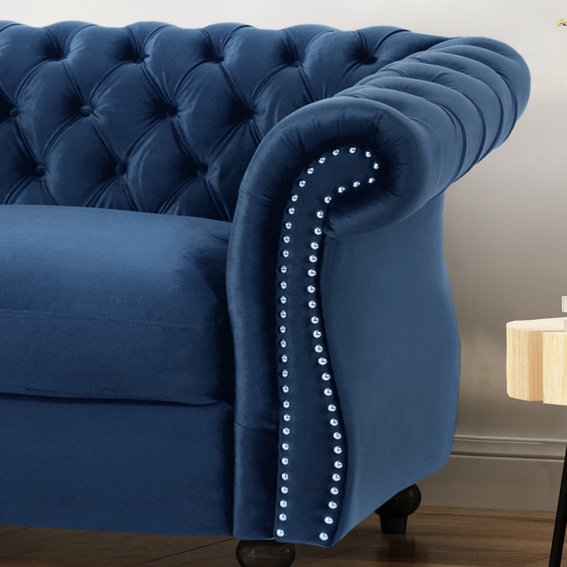 Fauteuil élégant à accoudoirs roulés en velours bleu marine classique avec bordure cloutée et capitonnage profond