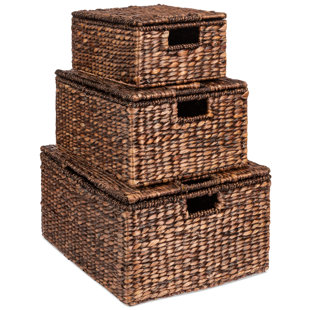 Close-up of lidded wicker storage boxes on bamboo stool Stock