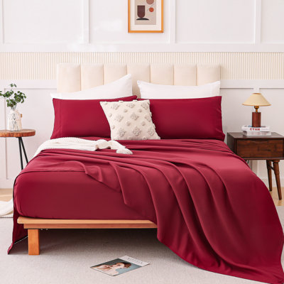 Ensemble quatre pièces rouge vin avec mélange de coton, peau et respirant pour un sommeil nu, avec des coutures effilochées, des tons de faible saturation, une couverture de lit double, un tissu de mélange d'impression, un confort de nuage
