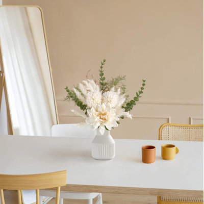 Petites fleurs artificielles dans un vase en céramique 
