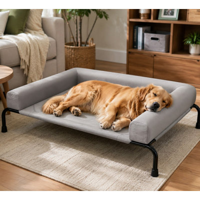 Grey elevated dog cot for large dogs, measuring 47.75" x 31", with bolsters and a breathable raised design intended for outdoor cooling.