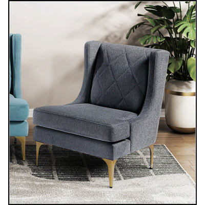 Fauteuil d'appoint moderne et luxueux à oreilles, revêtu de chenille, avec pieds en métal au fini doré, ressorts ensachés et surpiqûres en losange pour plus d'élégance et de confort.