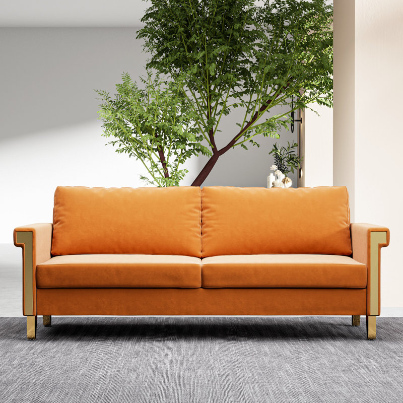 Mobilier de salon en velours orange avec pieds en métal doré et coussins profonds élégants