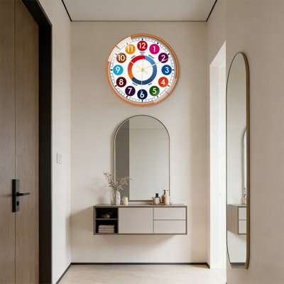 Educational children wall clock with vibrant color-coded numbers and minute guides, silent quartz movement & tempered glass front. Time-teaching decor for classrooms and kids rooms.