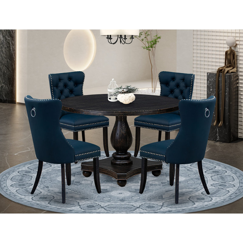 L'ensemble de table de salle à manger 5 pièces comprend une table ronde de 48 po avec piédestal et 4 chaises rembourrées en similicuir bleu marine, noir sablé