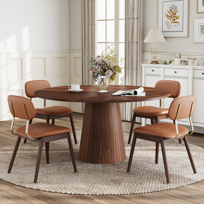 Ensemble de table et chaises de salle à manger rondes modernes de 119 cm (47 po) pour 4 à 6 personnes, avec pied central et chaises rembourrées.