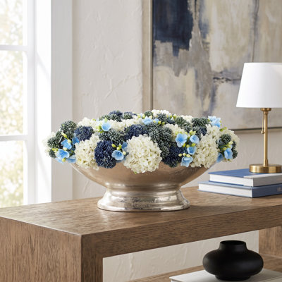 Hortensias et orpins disposés dans un vase en métal