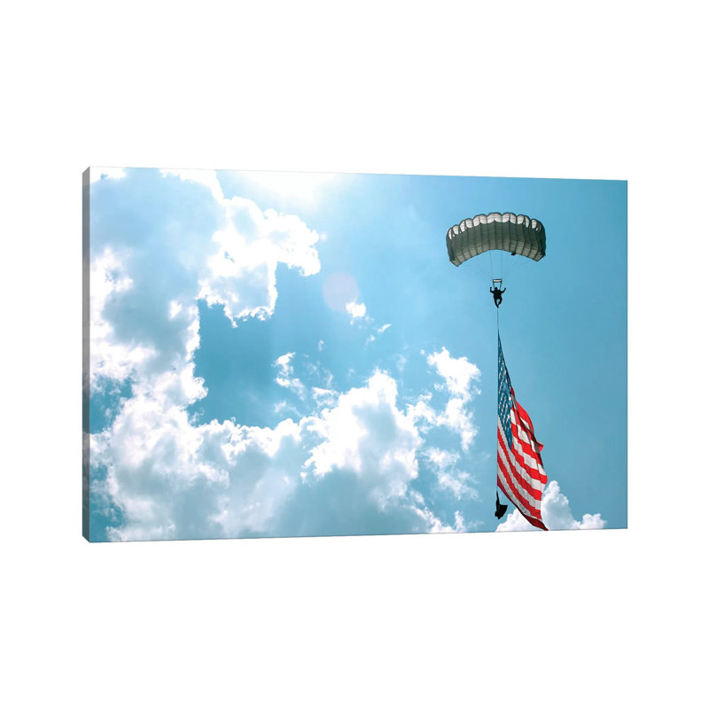 A Skydiver Carries A US Flag While Descending Through The Sky by Stocktrek Images - Wrapped Canvas Print