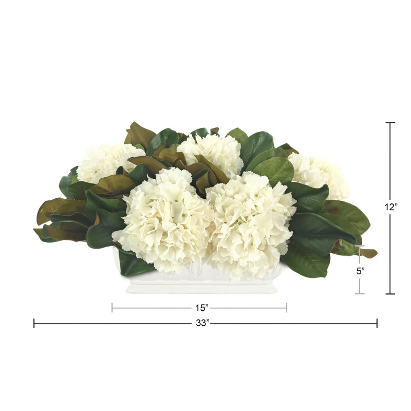 Arrangement floral avec hortensias et feuilles de magnolia