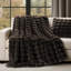 Dark brown faux fur throw blanket with a sculpted, ribbed texture draped over a white sofa.