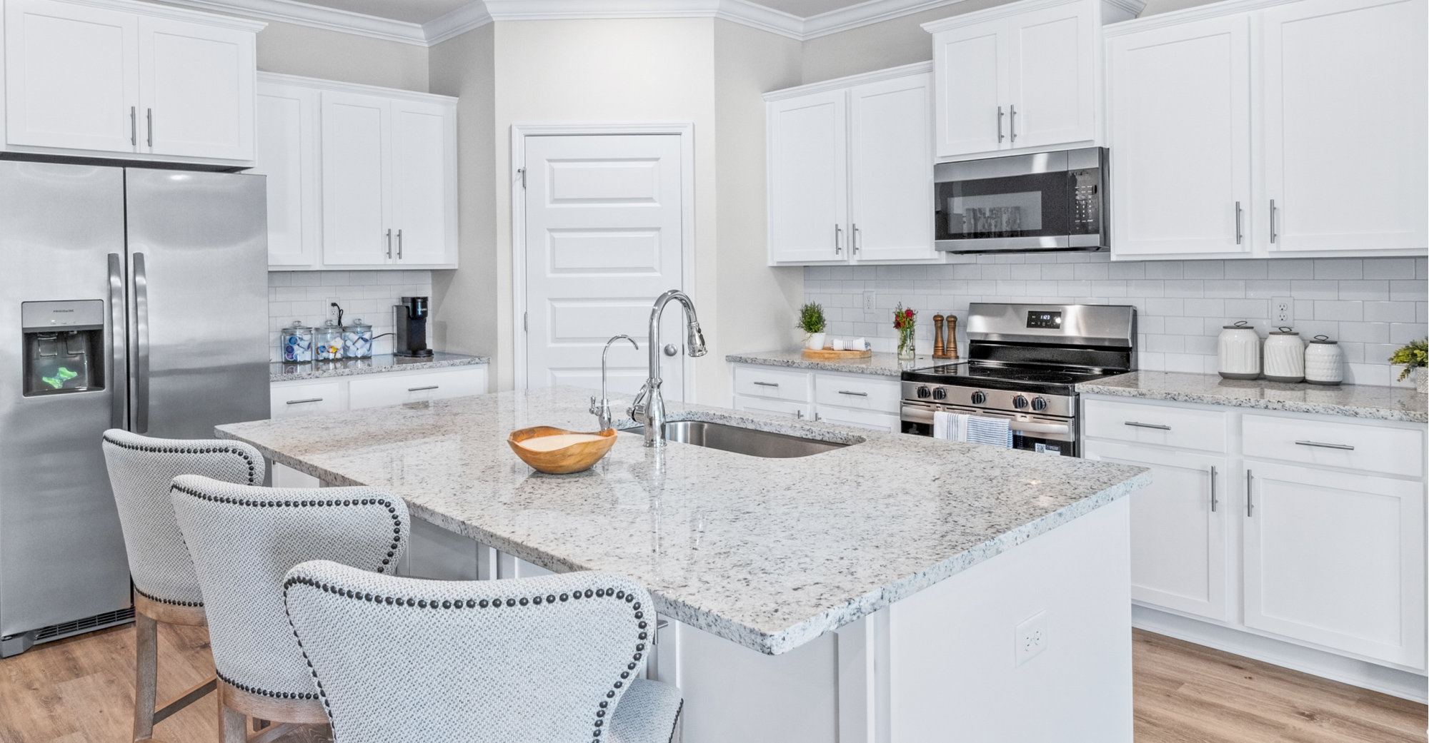 Bright white kitchen with stainless steel appliances.