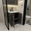 L'armoire de salle de bain noire de 24 pouces, jumelée à un lavabo en céramique blanche, présente un design moderne et est faite de matériaux imperméables et durables.