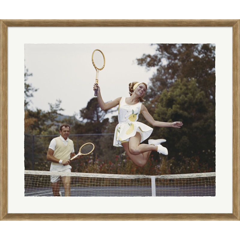 Couple on Tennis Court, Woman Jumping in Foreground Framed