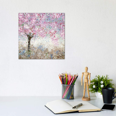 Square wall art depicting an impressionistic cherry blossom tree in pink and white tones, hanging above a desk.