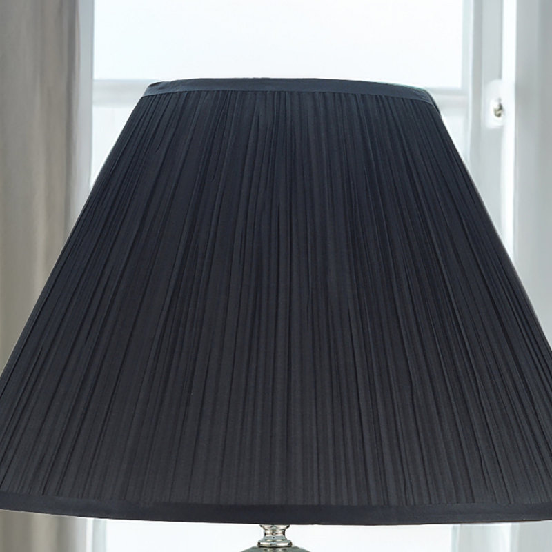 Élégante lampe de table artisanale avec base gris brillant, détails métalliques contrastants et abat-jour plissé pour un look moderne
