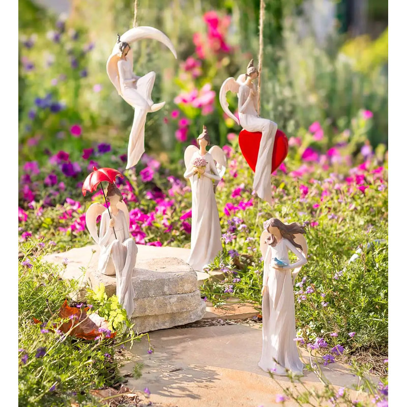 Statue d’ange assis avec un parasol rouge