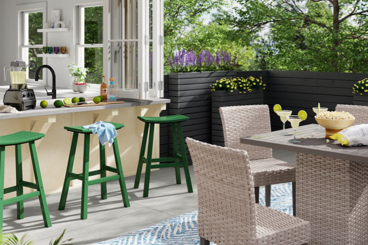 backyard patio with wicker conversation set and wooden table on neutral outdoor rug set beside fireplace