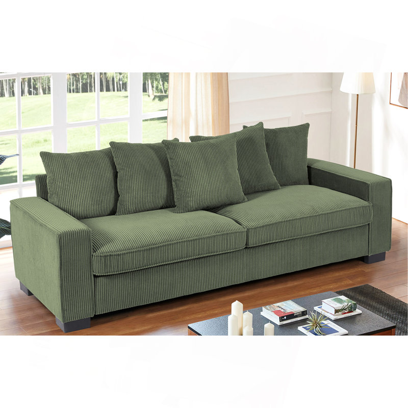 Luxueux canapé en velours côtelé avec coussins assortis, spacieux et confortable pour se détendre et recevoir.