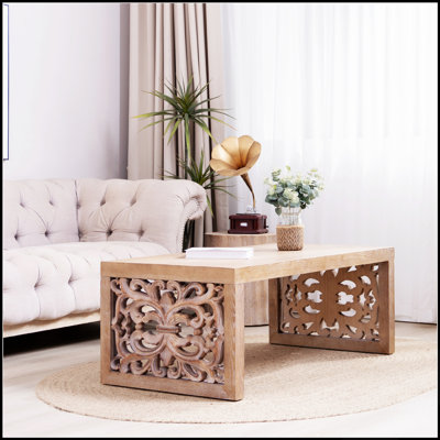 Table basse rustique en bois sculpté avec panneaux latéraux ornés, idéale pour les intérieurs traditionnels et bohèmes.