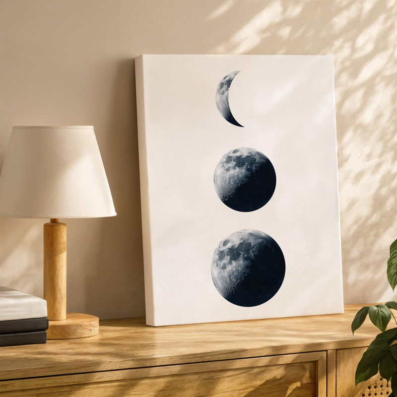 Toile, composition minimaliste mettant en vedette trois phases distinctes de la lune, art mural organisé verticalement contre une toile blanche Stark