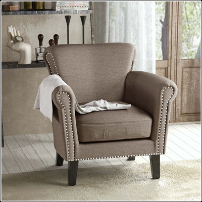 Fauteuil club avec garniture cloutée, accoudoirs roulés et pieds en bouleau