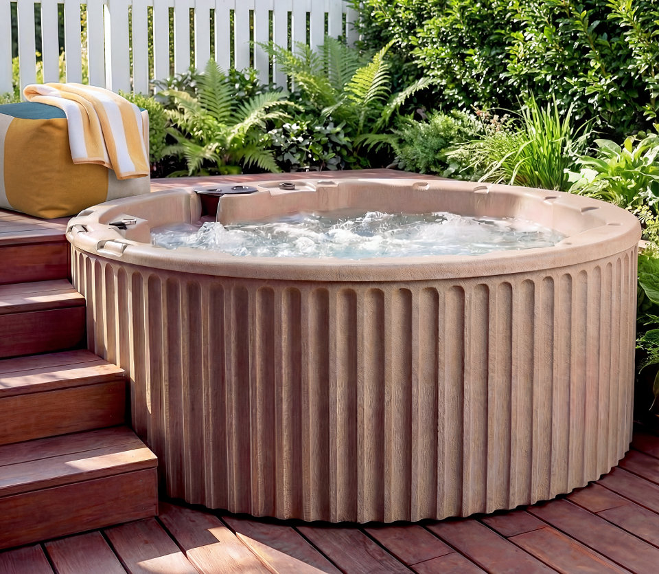 Spa rond sur terrasse et verdure.