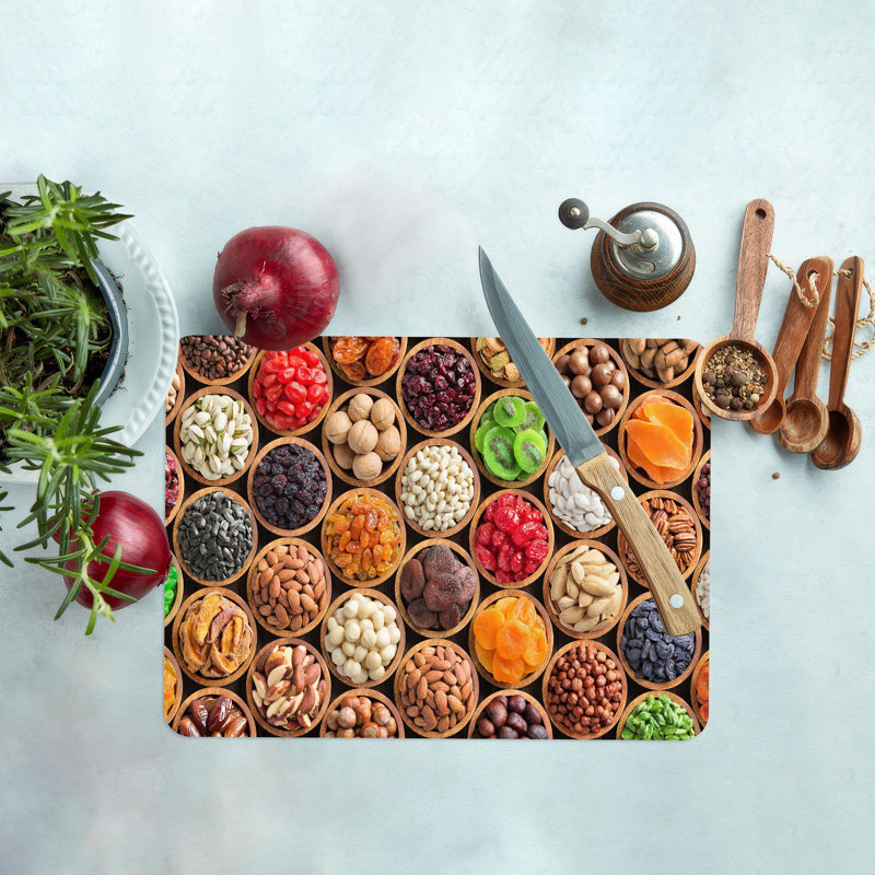 Élégante planche à découper en verre avec une représentation colorée moderne d'une planche à découper avec des fruits et des noix frais