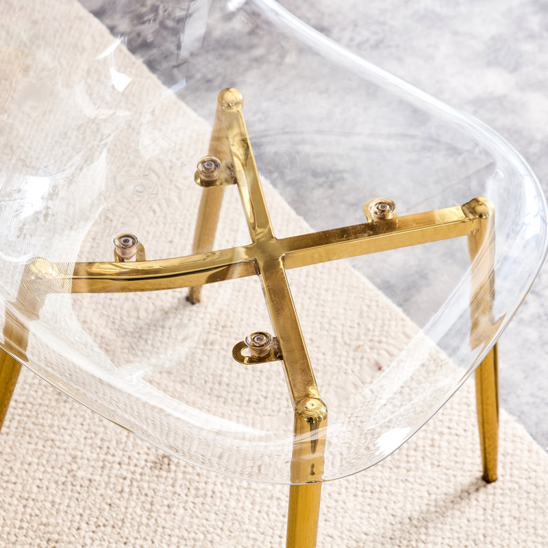 Chaise moderne et transparente, ergonomique avec des éléments en métal doré, polyvalente pour différents environnements et occasions Cadre doré ergonomique, idéale pour des espaces multiples