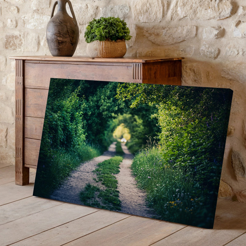 Toile, "Serene Winding Dirt Path", "Méandres à travers un paysage vert luxuriant", encadrée d'un feuillage dense