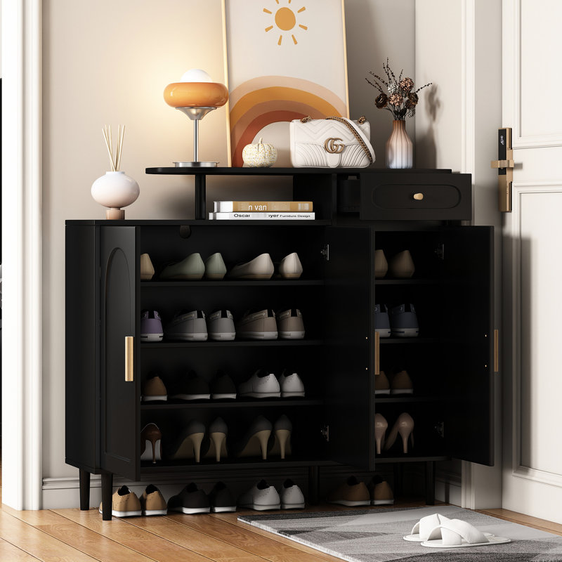 Armoire à chaussures Adonis Chic avec façade arquée et tiroir. Noir, tablettes réglables, grand espace de travail, portes de rangement noires en panneau de particules. Grand bureau, construction
