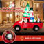 Grand père Noël conduisant une voiture gonflable