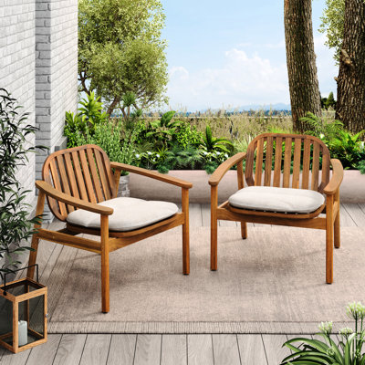 Deux fauteuils club avec coussins beiges, structure en bois, pieds en eucalyptus, dossier légèrement incurvé et assise à lattes, pour le jardin. Modèle 2 avec structure amovible, style moderne et confort extérieur.
