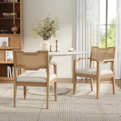 Ensemble de 2 chaises de salle à manger de style campagnard avec accoudoirs en bois, structure en contreplaqué d'hévéa, dossier en rotin tressé et assise rembourrée en lin beige, finition bois naturel, idéales pour une salle à manger, un restaurant ou une maison de style bord de mer.