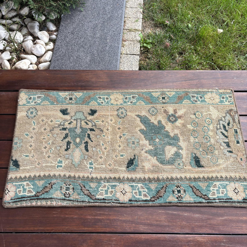 Petit tapis turc beige antique avec des motifs géométriques parfaits pour les petits espaces et ajoutant un charme rétro