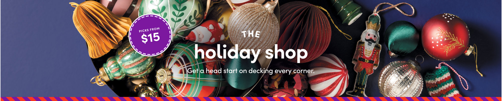 A taller mobile holiday banner reading 'THE holiday shop' in white text over an assortment of colorful Christmas ornaments, a nutcracker, and a peppermint bauble on a deep navy background.