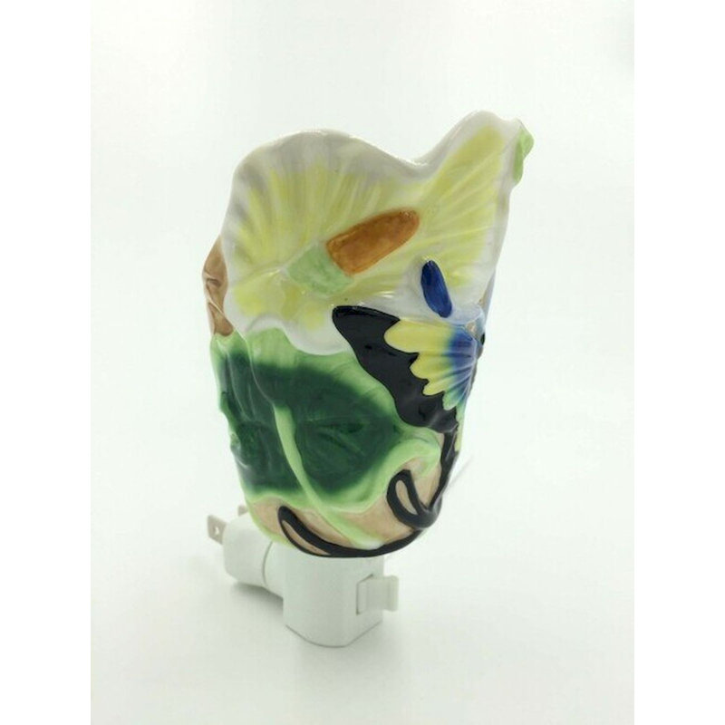 Papillon bleu sur une veilleuse en forme de bouton floral