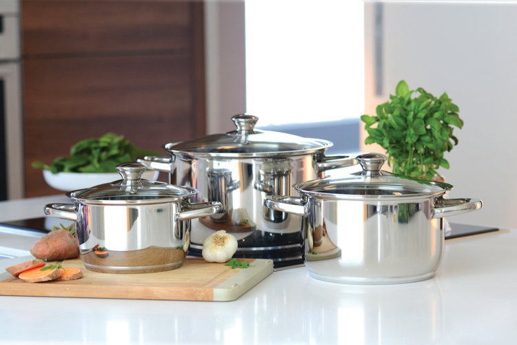 three stock pots of various sizes on a kitchen countertop