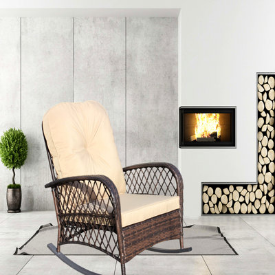 Fauteuil à bascule d'extérieur, assise spacieuse, structure en acier, idéal pour terrasse, jardin ou cour, pieds brun peu profonds, coussin épais, motif et structure.