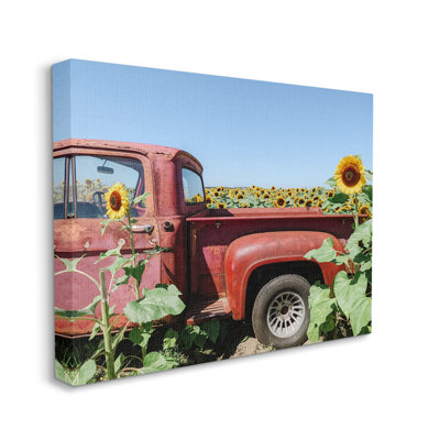 Camionnette rouge rétro au milieu d'un champ de tournesols - photographie sur toile