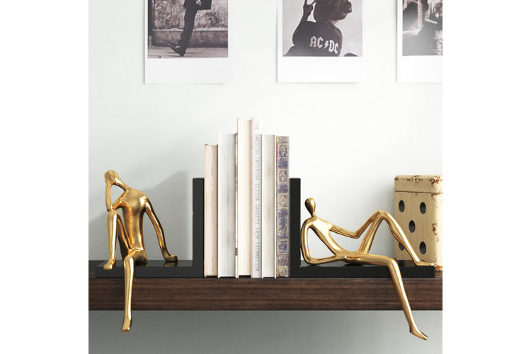Bookshelf with gold people-shaped aluminum bookends.
